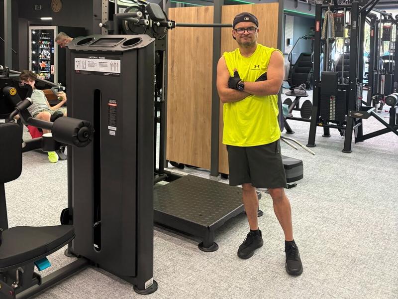 Pedro Gabriel en el gimnasio, de brazos cruzados, con una camiseta amarilla sin mangas